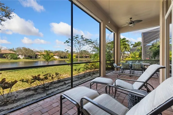 Sunroom with ceiling fan and a water view