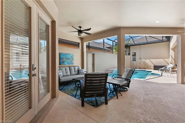 Sunroom / solarium with a pool and a ceiling fan