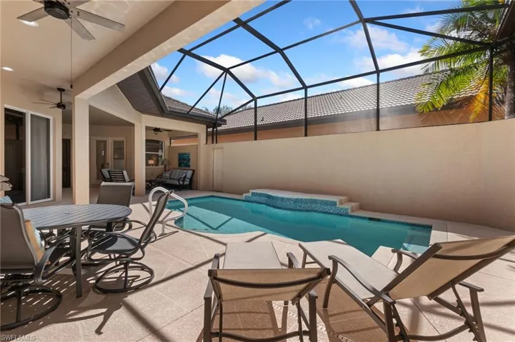 Outdoor pool with a lanai, a patio area, and ceiling fan
