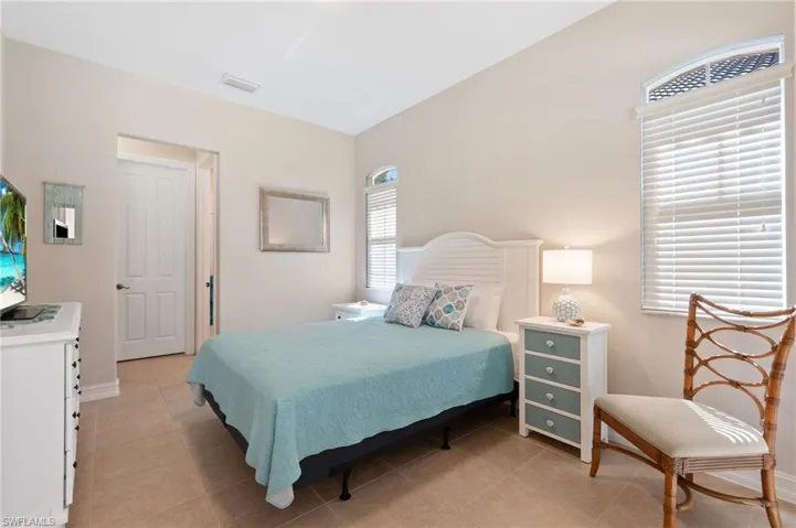 Bedroom with light tile patterned floors, visible vents, and baseboards