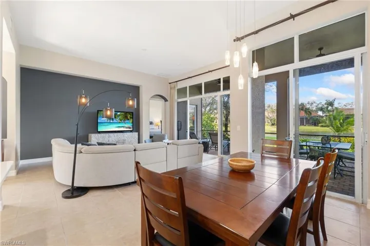 Dining space with arched walkways and light tile patterned flooring