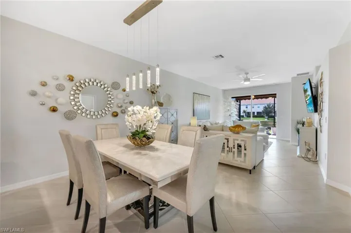 Dining space with ceiling fan and light tile floors