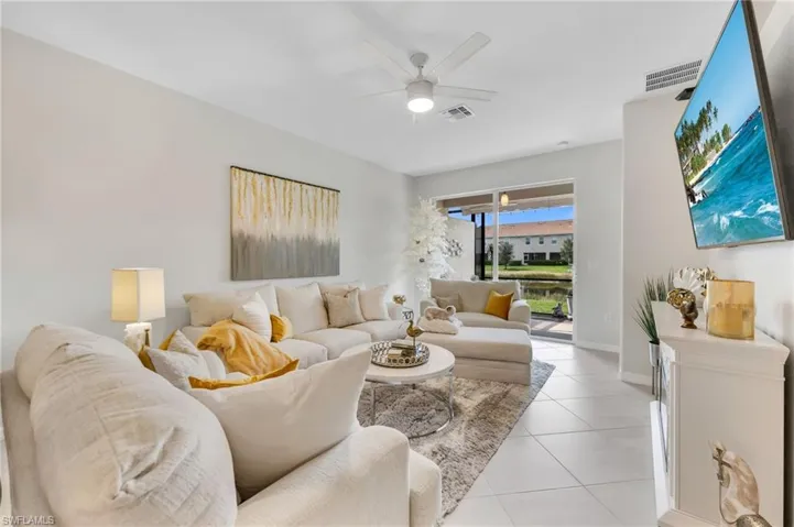 Living room with ceiling fan and light tile floors
