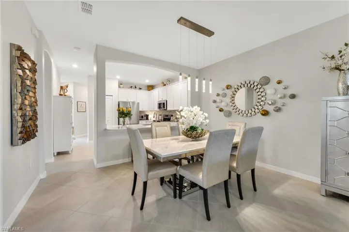 Dining space featuring light tile floors, upgraded light fixture and recessed lighting