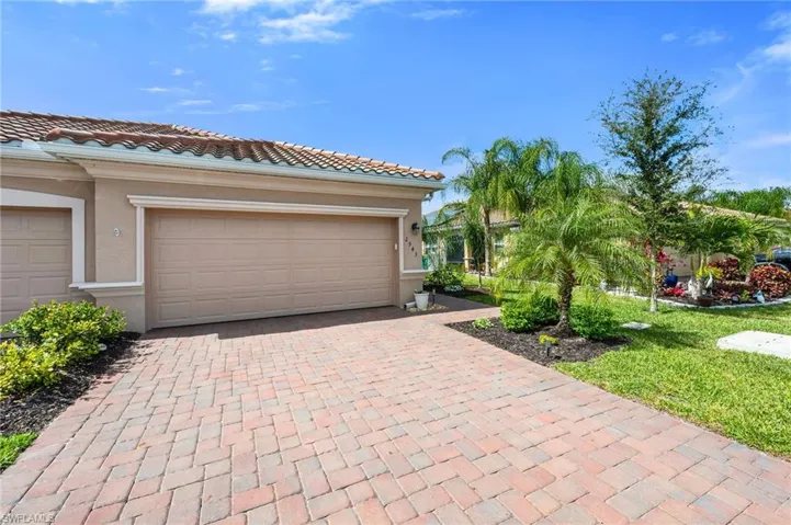 2 car garage featuring brick paver driveway