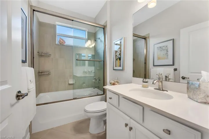 Full guest bath featuring vanity and shower / bath combo with upgraded glass doors