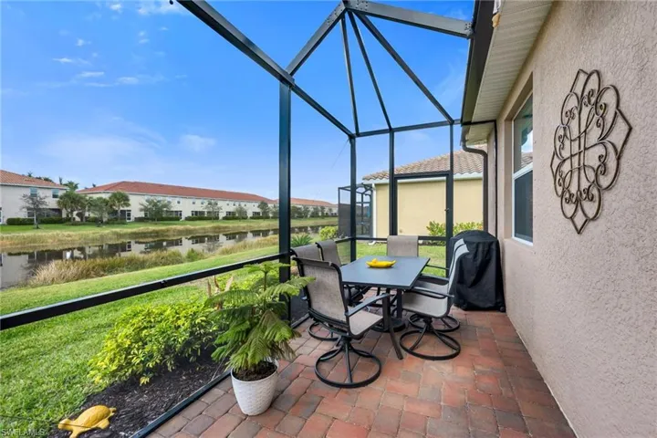 Extended Rear Lanai featuring outdoor dining space, a water/lake view, and brick paver patio
