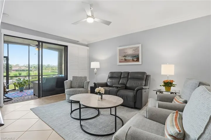 Tiled living room featuring crown molding and ceiling fan