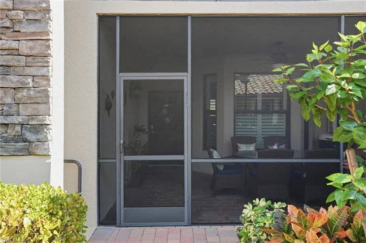 Doorway to property with stone siding, stucco siding, and a patio area