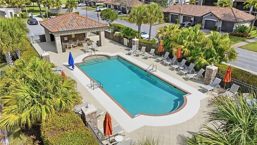 Community pool with a patio area and a residential view