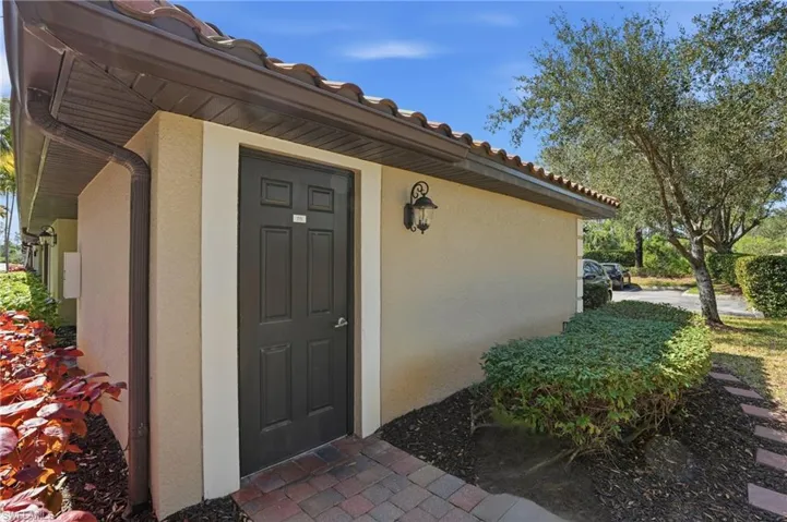 Property entrance with stucco siding and a tiled roof