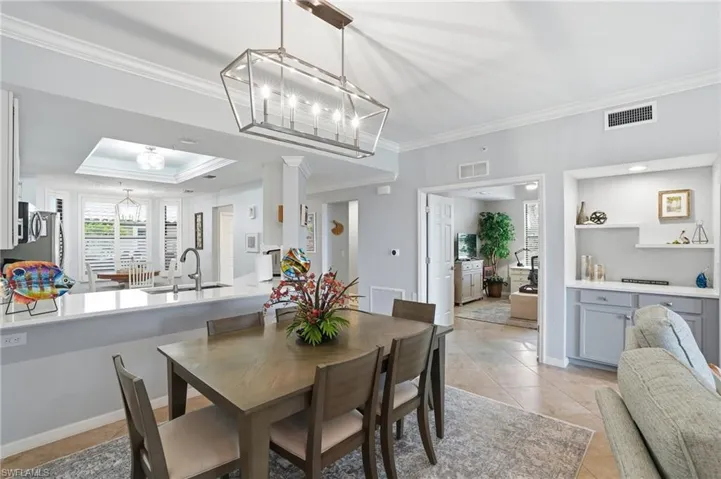 Dining room featuring ornamental molding, a chandelier, and light tile patterned floors