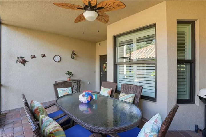 View of patio with outdoor dining area and a ceiling fan