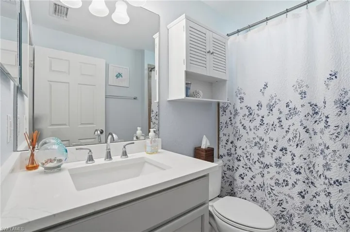 Full bathroom with vanity and curtained shower