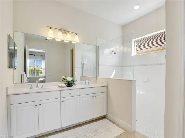 Bathroom with double vanity, a sink, ensuite bath, and a walk in shower