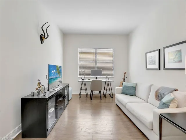 Den featuring baseboards and wood finished floors
