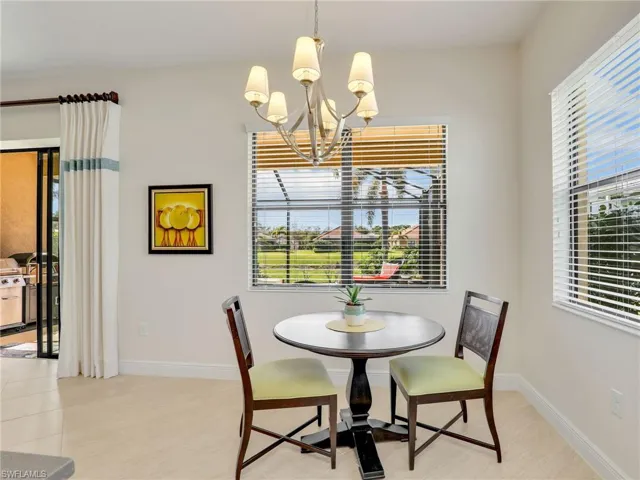 Dining area with a healthy amount of sunlight, baseboards, and a notable chandelier