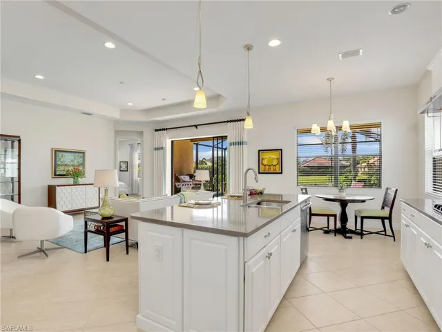 Kitchen with a raised ceiling, visible vents, a sink, and white cabinets