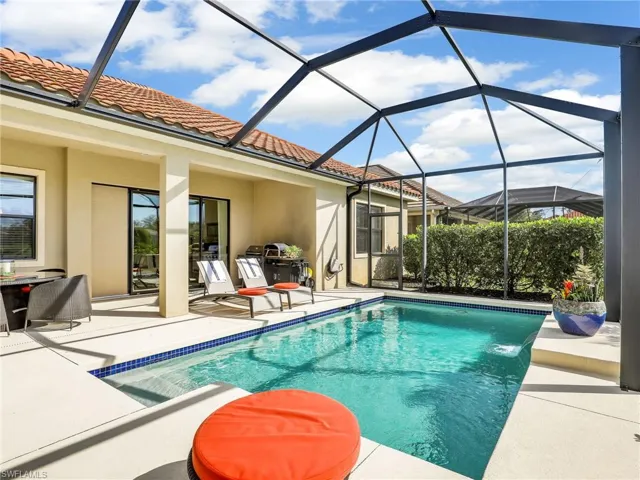 Pool featuring glass enclosure and a patio area