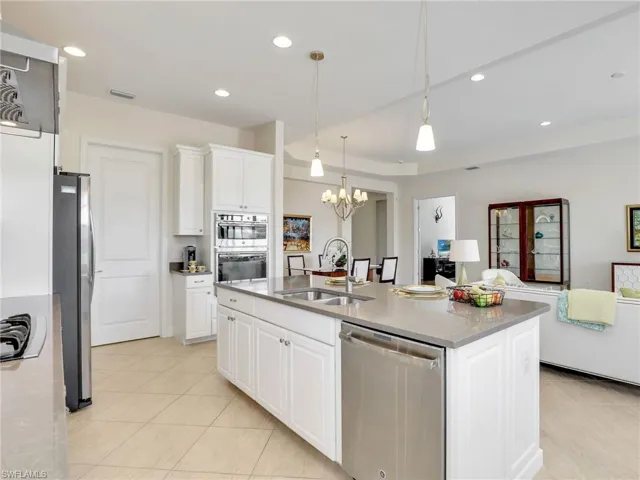 Kitchen featuring stainless steel appliances, convection oven, visible vents, open floor plan, a sink, and a chandelier