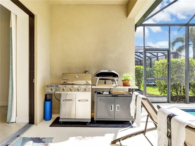 View of patio with glass enclosure and grilling area