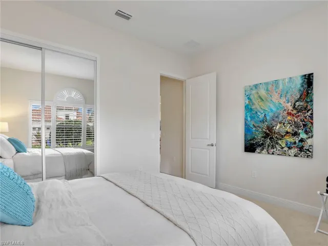 Bedroom featuring carpet floors, baseboards, visible vents, and a closet