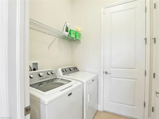 Washroom with laundry area and washer and clothes dryer