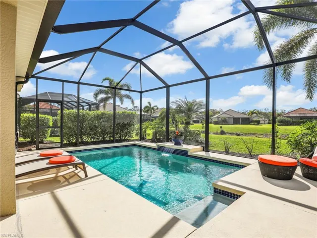 Pool featuring glass enclosure, a yard, and a patio area