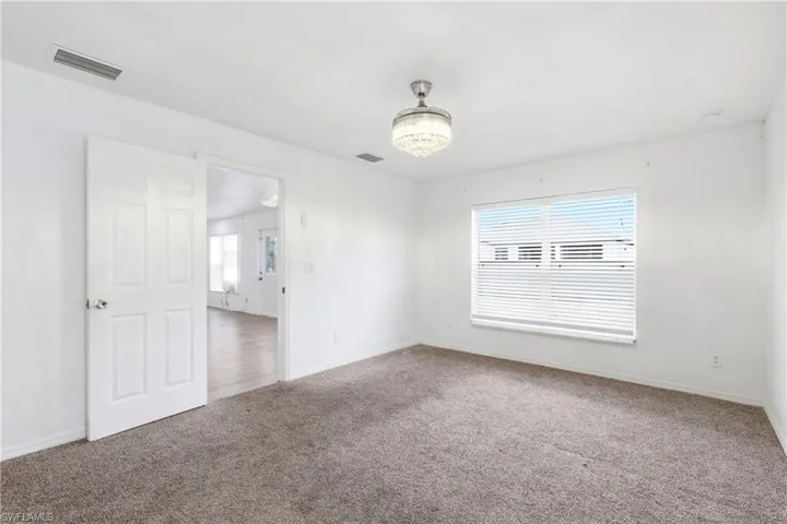 Carpeted spare room featuring baseboards