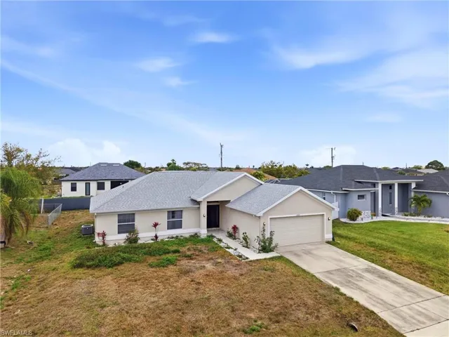 Single story home with stucco siding, an attached garage, a front yard, concrete driveway, and roof with shingles