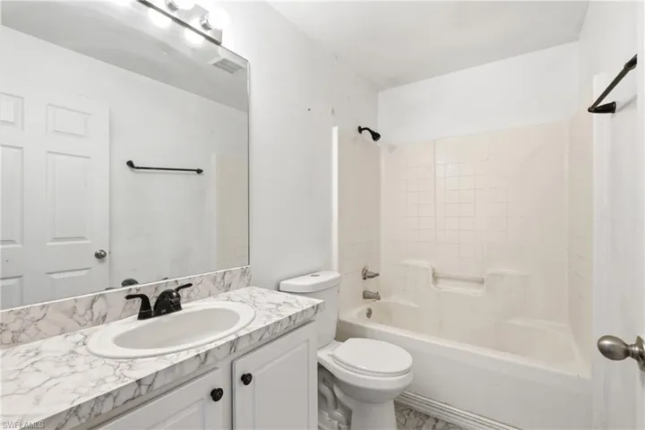 Bathroom with vanity and washtub / shower combination