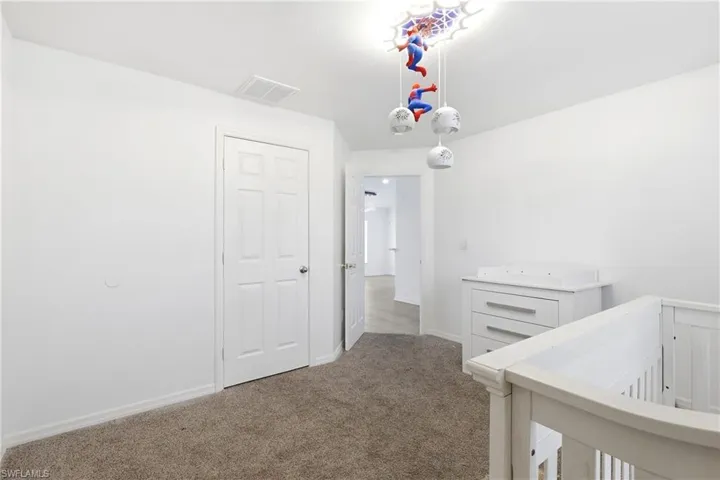 Hallway with carpet flooring and baseboards