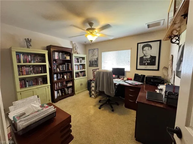 Home office featuring light colored carpet and ceiling fan