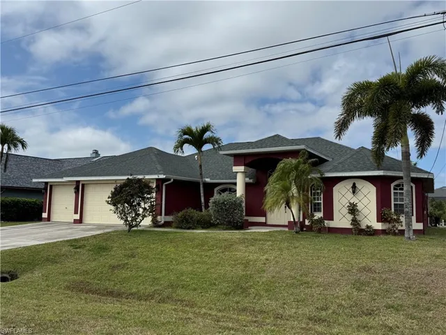 Ranch-style home featuring a shingled roof, an attached garage, a front yard, and driveway