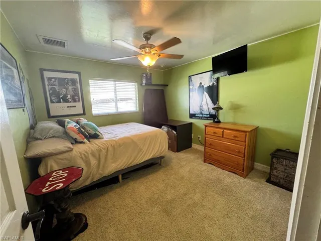 Bedroom with light colored carpet and ceiling fan