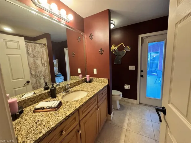 Full bathroom featuring a shower with shower curtain, vanity, and light tile patterned floors