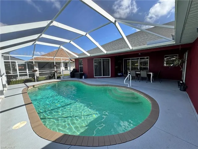 Swimming pool with a sunroom, a lanai, and a patio area