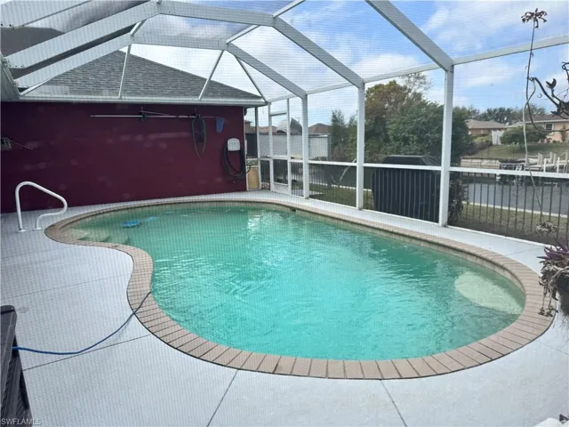 Swimming pool with glass enclosure, a patio area, and a sunroom