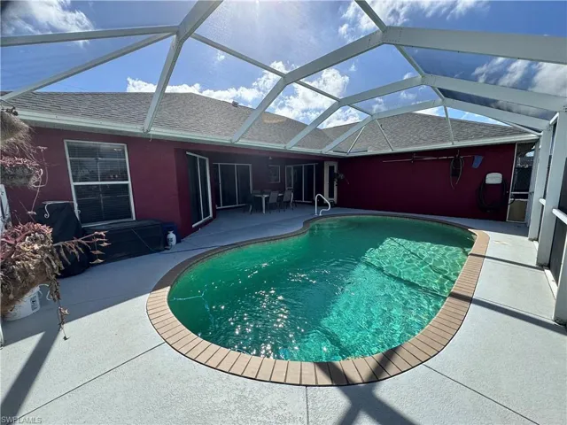 Swimming pool featuring a sunroom, a lanai, and a patio area