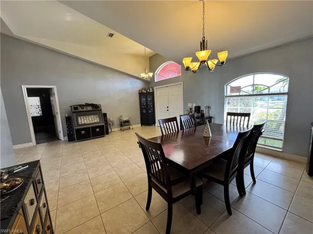 Dining area featuring suspended lighting, a high ceiling, and light tile patterned flooring