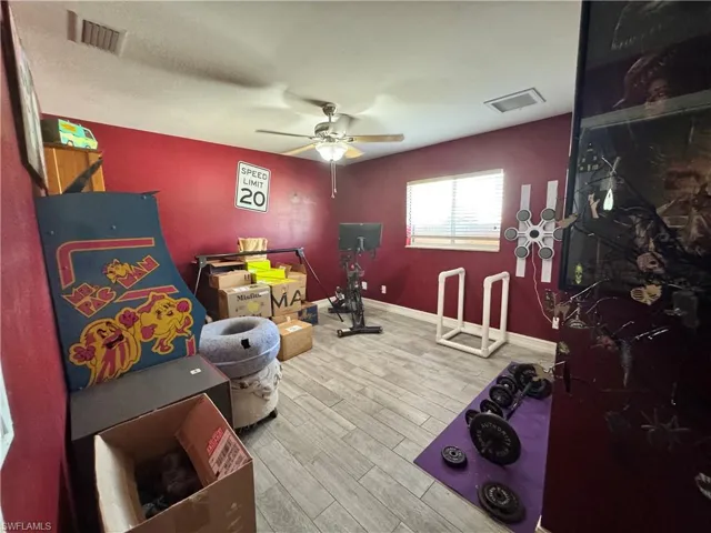 Game room with light wood finished floors and ceiling fan