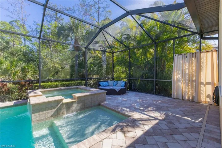 View of pool with an in ground hot tub, an outdoor living space, a lanai, and a patio area