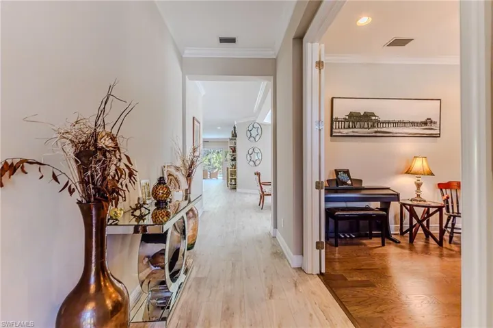 Hall featuring crown molding and light wood-type flooring
