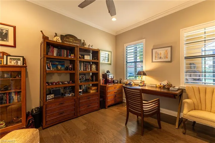 Office area featuring crown molding, ceiling fan, and dark hardwood / wood-style flooring