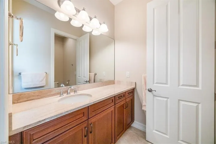 Bathroom featuring toilet, vanity, and tile patterned floors