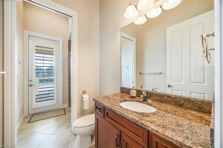 Bathroom featuring baseboards, vanity, tile patterned flooring, and toilet