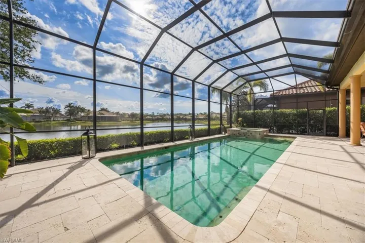 View of swimming pool with a patio area, a lanai, a pool with connected hot tub, and a water view