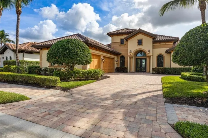 Mediterranean / spanish-style home featuring french doors, a tiled roof, an attached garage, stucco siding, and decorative driveway