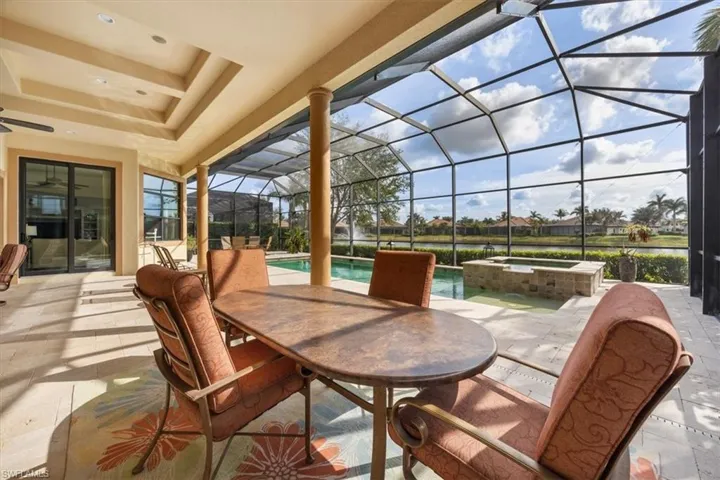 View of patio / terrace featuring outdoor dining space, a lanai, and a pool with connected hot tub