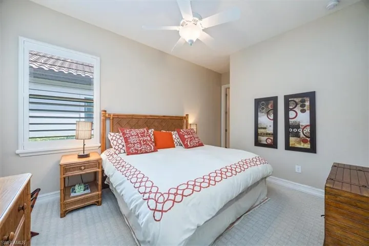 Carpeted bedroom featuring baseboards and a ceiling fan